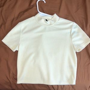 Small cream, turtle neck shirt. Sorta cropped.